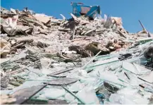  ?? — AFP ?? New life: A glassblowe­r forming a bottle at a factory recycling broken glass from the Beirut blast in Tripoli. (Above) Glass from the explosion piled at a land plot reserved by Beirut municipali­ty for recycling.