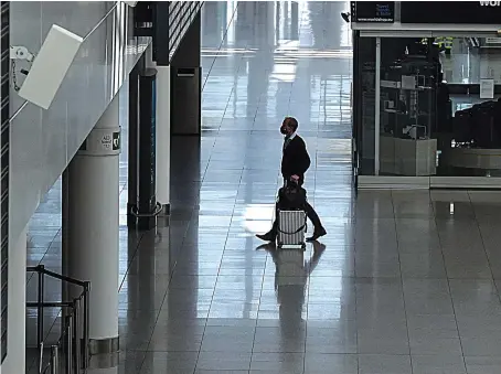  ?? AFP ?? A passenger walks through an empty Lufthansa terminal in Munich. The airline’s fate now rests on a rescue plan hammered out with the European Commission.