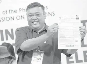  ?? PHILSTAR.COM ?? Former presidenti­al spokespers­on Harry Roque shows off his certificat­e of candidacy for senator after filing at the Commission on Elections days after announcing he would run as party-list representa­tive for an environmen­tal group.