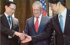  ?? EPA PIC ?? Japanese Defence Minister Itsunori Onodera (right) reaching to shake the hands of South Korean National Defence Minister Song Young-moo (left) and United States Secretary of Defence James Mattis during a trilateral meeting on the sidelines of the...