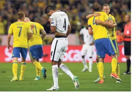  ?? (Photo AFP) ?? Raphaël Varane, déçu, au milieu de Suédois ravis. Drôle de soirée à Solna.