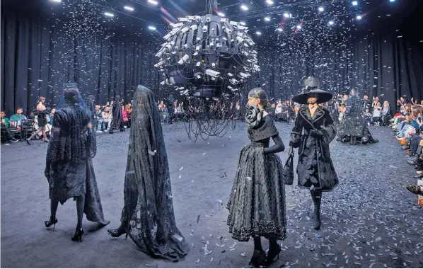  ?? ?? Black confetti fell from the ceiling over models dressed in black lace outfits designed by Richard Quinn in tribute to Queen Elizabeth. The show was held at Lindley Hall in Westminste­r during London Fashion Week