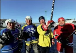  ?? LI YANG / FOR CHINA DAILY ?? Xie Hongli (second from left), who is 72, and his teammates gather after practicing ice hockey on the frozen Songhua River as temperatur­es in Harbin dropped to as low as 20 C on Wednesday.