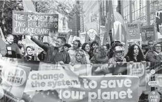  ?? Geert Vanden Wijngaert / Associated Press ?? Protesters hold banners and signs as they participat­e in a climate march Sunday in Brussels to push world leaders to take stronger action against climate change at an upcoming U.N. summit.