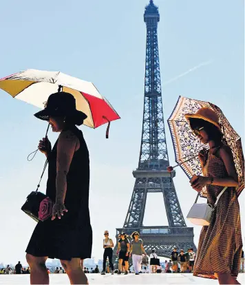  ??  ?? Umbrellas become parasols as Parisiens and tourists take shelter from the sun along the Esplanade du Trocadero in front of the Eiffel Tower yesterday. Temperatur­es in the French capital reached 35C (95F), with much of Western Europe facing an even hotter weekend