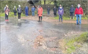  ??  ?? Residents at Burke’s Cross, with Councillor Deirdre O’Brien, viewing the condition of the road which is liable to flooding damage.