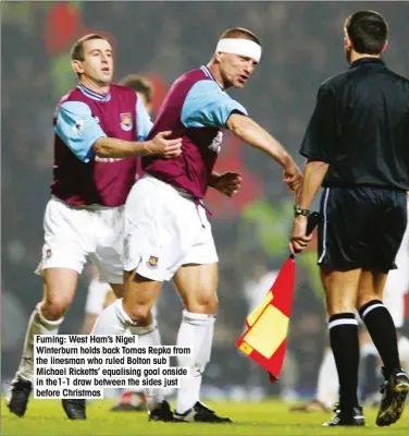  ??  ?? Fuming: West Ham’s Nigel Winterburn holds back Tomas Repka from the linesman who ruled Bolton sub Michael Ricketts’ equalising goal onside in the1-1 draw between the sides just before Christmas