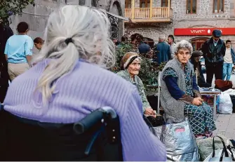  ?? Vasily Krestyanin­ov/Associated Press ?? Ethnic Armenian elderly women from Nagorno-Karabakh rest after arriving in Goris, Armenia, on Thursday. Officials say over half of the enclave’s 120,000 residents have fled for Armenia.