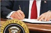  ?? EVAN VUCCI / ASSOCIATED PRESS ?? President Donald Trump signs his executive order on health coverage in the White House on Thursday. Federal agencies would have to implement his plans, which likely would take several months.