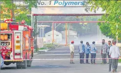  ?? PTI PHOTO ?? Firefighte­rs stand outside the LG Polymers factory as styrene vapours linger at a distance. n