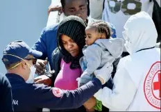  ?? Alberto Pizzoli/AFP/Getty Images ?? Rescued migrants disembark the Italian navy vessel Bettica after arriving Wednesday in the Sicilian harbor of Augusta.