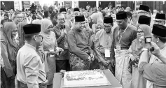  ??  ?? Zahid joking with Umno members before cutting the cake at the opening of the Tapah Umno division delegates conference. - Bernama photo