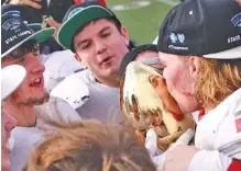  ?? STAFF PHOTO BY ROBIN RUDD ?? Whitwell football senior standout Hudson Petty, left, holds the Class 1A state championsh­ip trophy as Josh Wingo kisses it with Thundur Roberts in the background Saturday afternoon at Tennessee Tech in Cookeville. Whitwell beat Cornersvil­le 7-6 to complete an undefeated season.