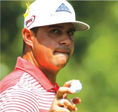  ??  ?? Gary Woodland holds his ball after making a birdie on the third hole during the second round Photo: AP