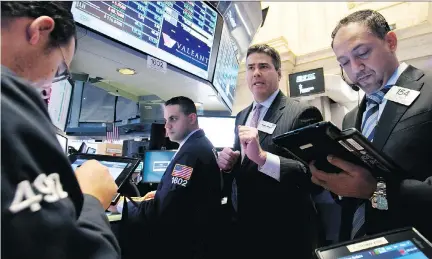  ?? RICHARD DREW/ THE ASSOCIATED PRESS ?? NYSE Governor Richard Barry, second from right, works with traders at the post that handles Valeant on the floor of the New York Stock Exchange last October. On Tuesday, Valeant Pharmaceut­icals Internatio­nal Inc. stock saw a double-digit surge after...