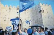  ?? AP FILE ?? Israelis wave national flags outside the Damascus Gate in Jerusalem’s Old City.