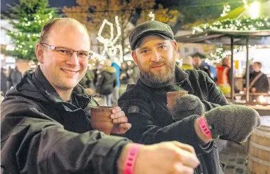  ?? BILD: Sascha Stüber ?? Haben den Becher Feuerzange­nbowle nur mit gültigem Kontroll-Bändchen bekommen (von links): Die NWZ-Redakteure Patrick Buck und Wolfgang Alexander Meyer.