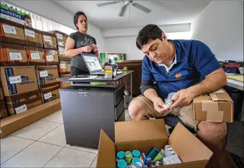  ?? ALLEN EYESTONE / THE PALM BEACH POST ?? Diego Torres and his wife, Johana, run a freight shipping business out of their home in West Palm Beach. Every week, customers who were born in Venezuela drop off boxes of medicine, toiletries and items to be sent to relatives there, where the...