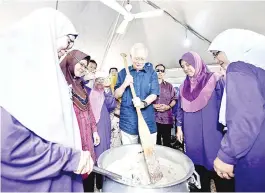  ??  ?? Najib stirring the “bubur lambuk” at his residence, Sri Kenangan in Pekan yesterday.The program is held annually by the former prime minister for the people to break their fast.-Bernama photo