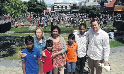  ?? PHOTOS: PAUL TAYLOR ?? Community call . . . Basket of Blessings Queenstown organiser Tam Schurmann (back left) with Dinesha Amarasingh­e, Sam Wijerathne, CluthaSout­hland MP Hamish Walker and children Subath, Senath and Binath at Queenstown Village Green.