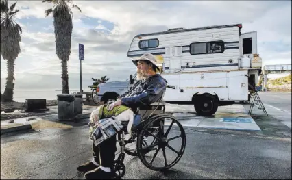  ?? ANA VENEGAS/ORANGE COUNTY REGISTER ?? Brian Blackburn, 57, and his dog Doolie spend days at Doheny State Beach in and around their camper. Blackburn is disabled and goes through the daily ritual of spending days at the beach followed by searching for street parking at night. Doheny State...