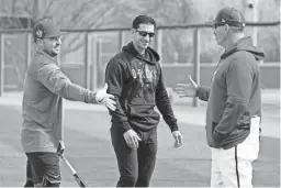  ?? ROB SCHUMACHER/THE REPUBLIC/USA TODAY NETWORK ?? Diamondbac­ks third baseman Buddy Kennedy greets General Manager Mike Hazen, center, and manager Torey Lovullo, right, during spring training workouts at Salt River Fields on Friday.