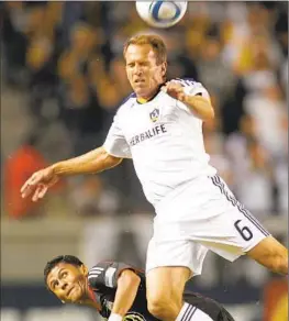  ?? Lori Shepler Associated Press ?? EDDIE LEWIS, right, of the Galaxy battles D.C. United’s Andy Najar for the ball in 2010. Lewis’ TOCA Football has warehouse-size training facilities in 39 cities.