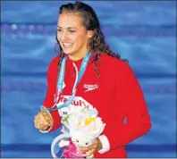  ?? CP PHOTO ?? Canada’s Kylie Jacqueline Masse shows off her gold medal after the women’s 100-metre backstroke final during the world swimming championsh­ips in Budapest, Hungary, Tuesday.