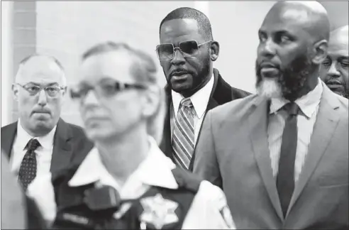  ?? ANTONIO PEREZ/CHICAGO TRIBUNE ?? R&B singer R. Kelly, center, shown in May arriving for a divorce court hearing in Chicago, is facing new federal indictment­s in Chicago and New York.