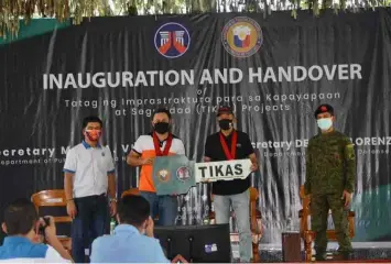  ?? (DPWH) ?? SYMBOLIC TURNOVER. Public Works and Highways Secretary Mark Villar (2nd from left) symbolical­ly turns over completed infrastruc­tures inside Camp Tecson to Defense Secretary Delfin Lorenzana (2nd from right).