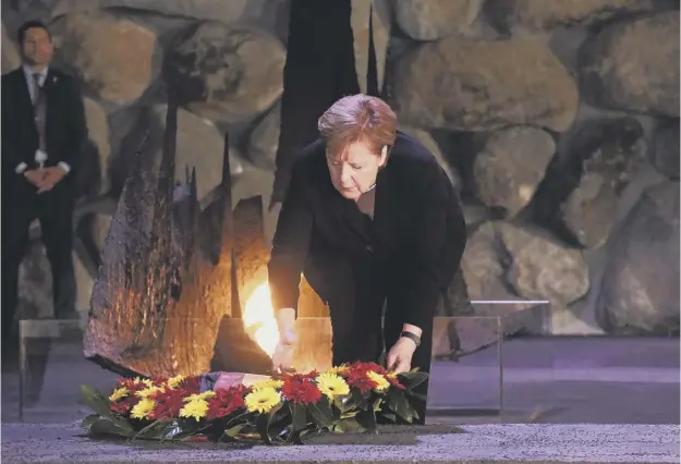  ?? PICTURE: DEBBIE HILL/AFP/GETTY IMAGES ?? 0 Angela Merkel lays a wreath of flowers in the Hall of Remembranc­e at the Yad Vashem Holocaust Museum in Jerusalem