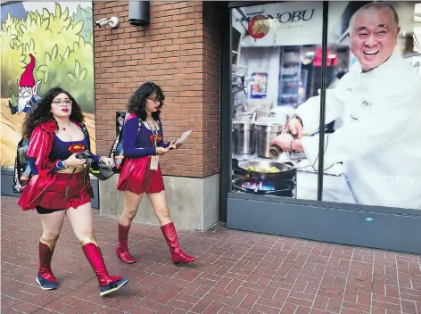  ?? RICHARD VOGEL/THE ASSOCIATED PRESS ?? Women dressed as Supergirl walk along a downtown San Diego street during 2018 Comic-con.