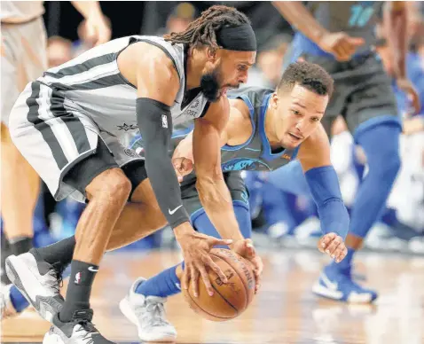  ?? Tom Pennington / Getty Images ?? Patty Mills beats Dallas rookie Jalen Brunson to a loose ball. Mills hit 4 of 10 from long range and finished with 14 points off the bench.