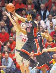  ?? GREG SORBER/JOURNAL ?? UNLV’s Jovan Mooring (30) reaches for a loose ball in front of UNM’s Dane Kuiper (14). The Lobos are giving up too many points off turnovers, coach Craig Neal says.