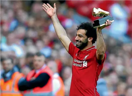  ?? GETTY IMAGES ?? Liverpool’s Mohamed Salah shows off his golden boot award after scoring in the 4-0 win against Brighton & Hove Albion at Anfield to finish top scorer in the Premier League.
