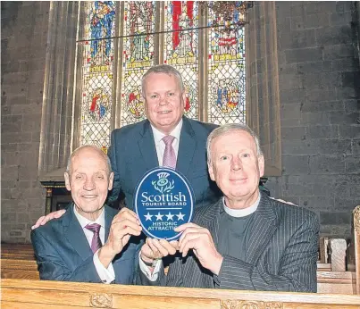  ?? Picture: Angus Findlay. ?? VisitScotl­and regional director Jim Clarkson, back, made the presentati­on to Dr John Hulbert and the Rev John Murdoch.