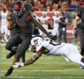  ??  ?? Houston quarterbac­k Greg Ward Jr. (1) breaks the tackle of UConn linebacker Vontae Diggs en route to a 30-yard touchdown in the first half of a game, Thursday in Houston.