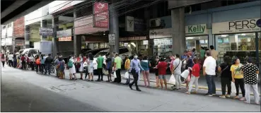  ?? AARON FAVILA — THE ASSOCIATED PRESS ?? People wait along a road to buy protective face masks at a store in Manila, Philippine­s, in January. Fear of the spreading coronaviru­s has led to a global run on sales of face masks despite medical experts’ advice that most people who aren’t sick don’t need to wear them.