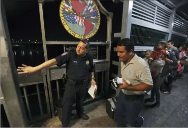  ?? FERNANDO LLANO — THE ASSOCIATED PRESS FILE ?? A U.S. border patrol officer directs a Nicaraguan migrant family, who is applying for asylum in the U.S., over Internatio­nal Bridge 1from Nuevo Laredo, Mexico, into Laredo, Texas, for an interview with immigratio­n officials Sept. 17, 2019.