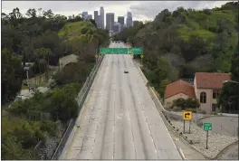  ?? MARK J. TERRILL — THE ASSOCIATED PRESS FILE ?? Extremely light traffic moves in the mid-afternoon along the 110 Harbor Freeway toward downtown Los Angeles on March 20, 2020.