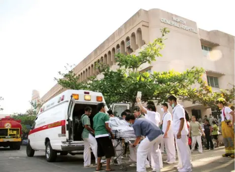  ?? JOY TORREJOS ?? A patient at the North General Hospital is wheeled into a waiting ambulance. The hospital management decided to transfer some of its patients to another facility after a fire hit the hospital last week.