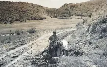  ??  ?? The trials that early motorcycli­sts endured were documented in club photos like this one, marked on the back, “Road to Cochrane.”
