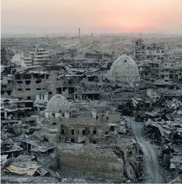  ?? FELIPE DANA / THE ASSOCIATED PRESS ?? The sun sets behind destroyed buildings in the west side of Mosul, Iraq. The nine-month fight to defeat Islamic State fighters ended in a crescendo of bombardmen­t that damaged or destroyed a third of its historic Old City.