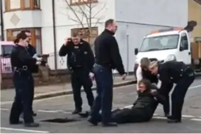  ??  ?? Saved: The man is dragged out by police who used crowbars to remove the drain cover