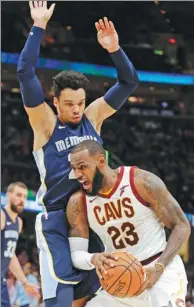  ?? TONY DEJAK / AP ?? LeBron James of the Cleveland Cavaliers drives against Dillon Brooks of the Memphis Grizzlies during Saturday’s NBA game in Cleveland. James scored 34 points as the Cavs beat the Grizzlies 116-111 for their 11th straight victory.