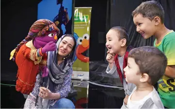  ??  ?? Afghan children meet Sesame street Muppet ‘Zari’ after a recording at a television studio in Kabul. — AFP photo