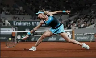  ?? THIEBAULT CAMUS — THE ASSOCIATED PRESS ?? Ukraine's Lesia Tsurenko plays a shot against Poland's Iga Swiatek during their first-round match at the French Open in Paris on Monday. Swiatek cruised to a 6-2, 6-0victory to advance in the tournament.