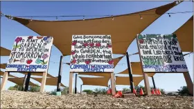  ?? ROSS D. FRANKLIN — THE ASSOCIATED PRESS ?? Signs adorn a common area at Spaces of Opportunit­y community gardens May 18in Phoenix.