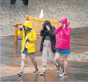  ?? Picture: Steve MacDougall. ?? People make their way through the rain in Dundee city centre yesterday.