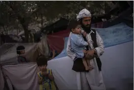  ?? BERNAT ARMANGUE — THE ASSOCIATED PRESS ?? A displaced Afghan family waits for food donations at a camp for internally displaced persons in Kabul, Afghanista­n, on Monday.